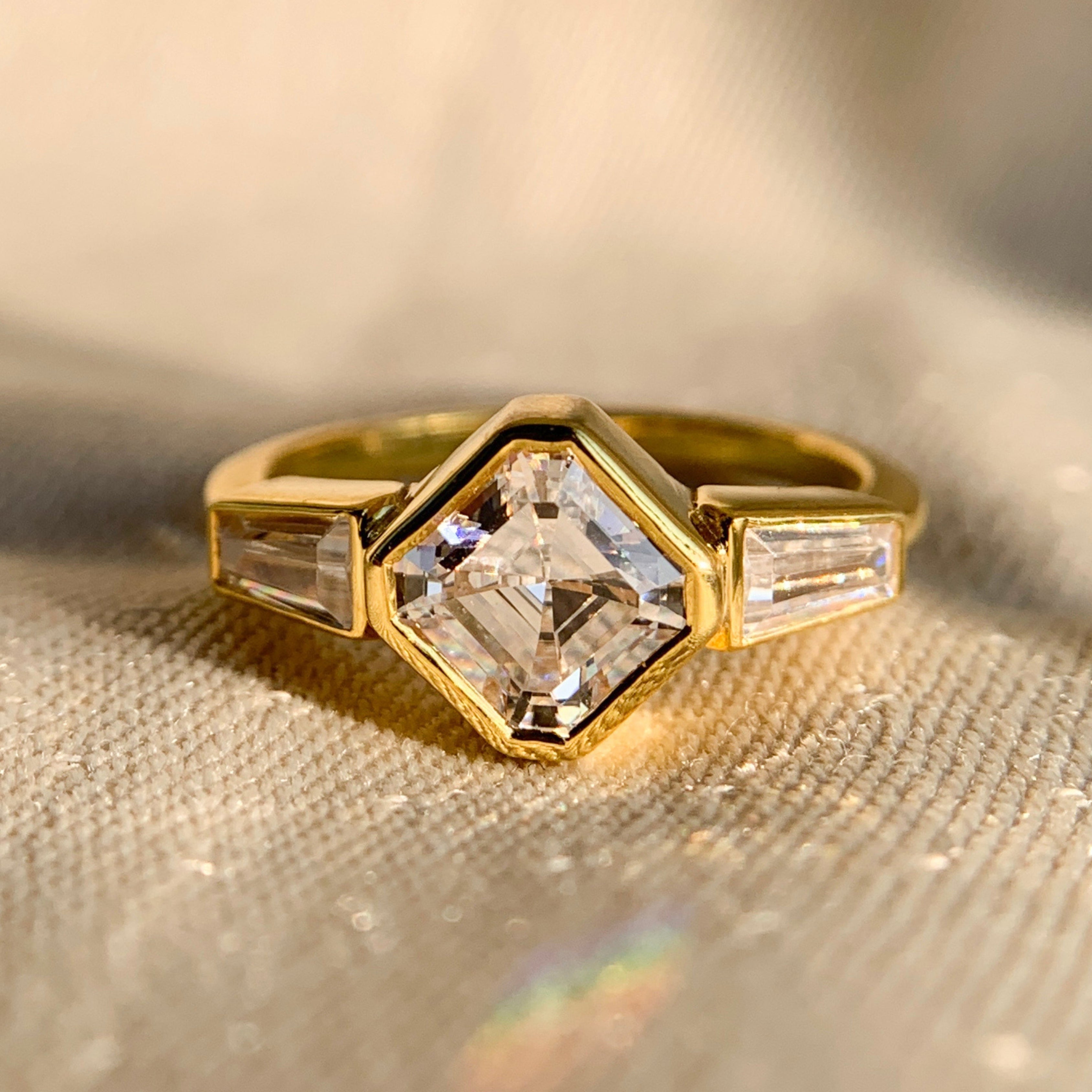 Elegant Asscher and baguette bezel set three stone engagement ring in white gold